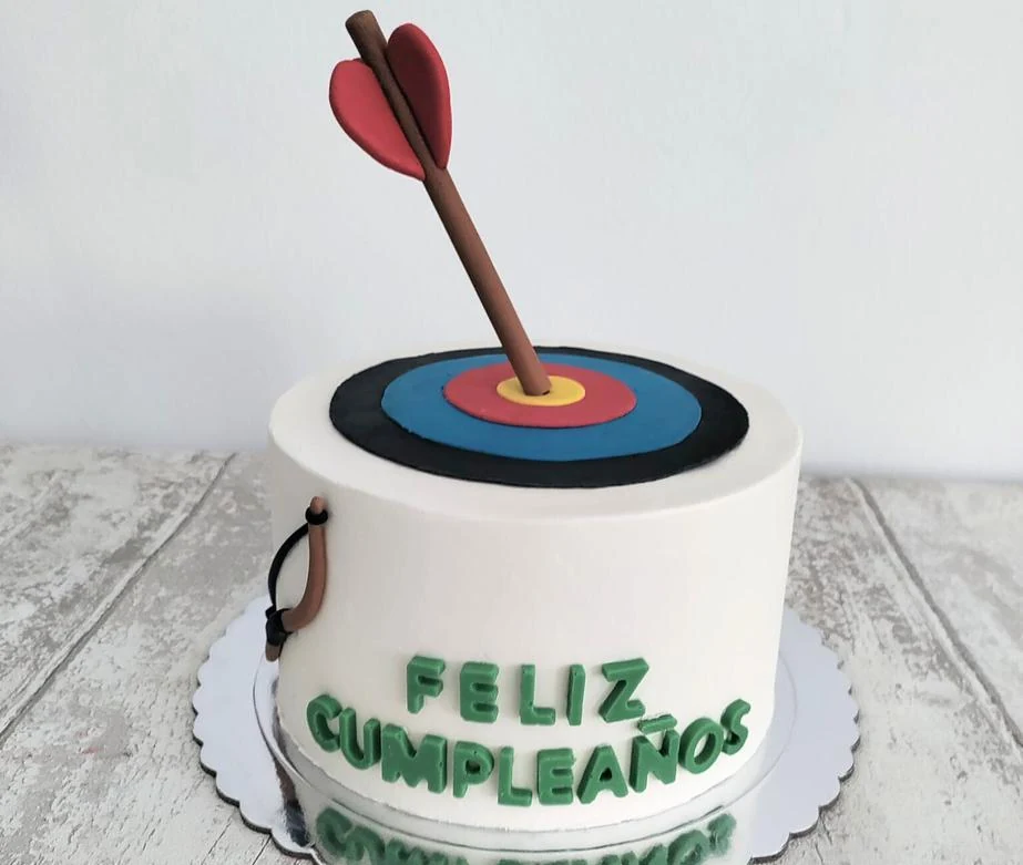 Tarta de cumpleaños con una diana y un dardo