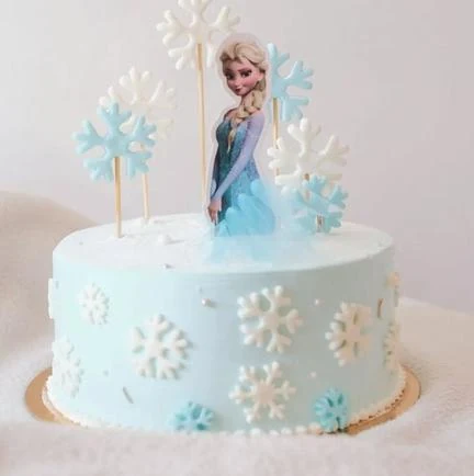 Tarta azul y blanca decorada con copos de nieve de Frozen